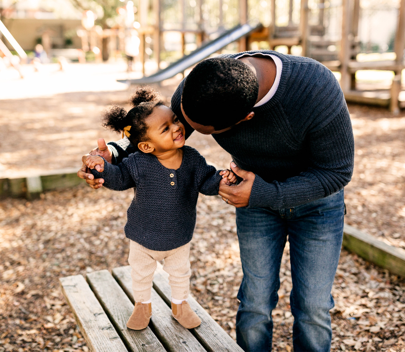 Un papa qui aide sa petite fille à marcher