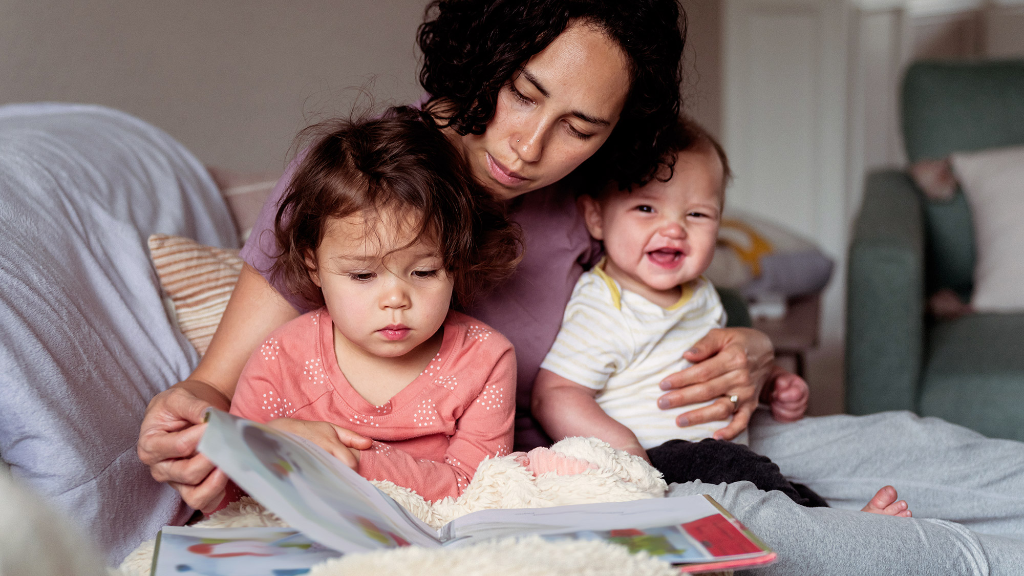 a mom reading a book to her to child