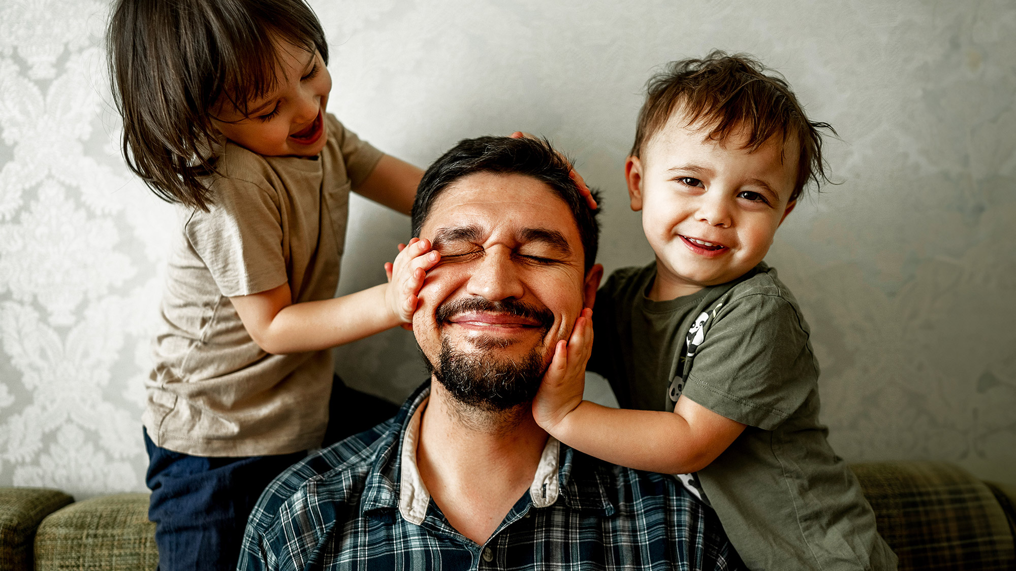 a dad laughing with his two kids